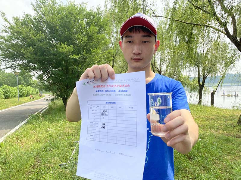 志愿者展示湯湖水質監(jiān)測報告。楊瑾攝