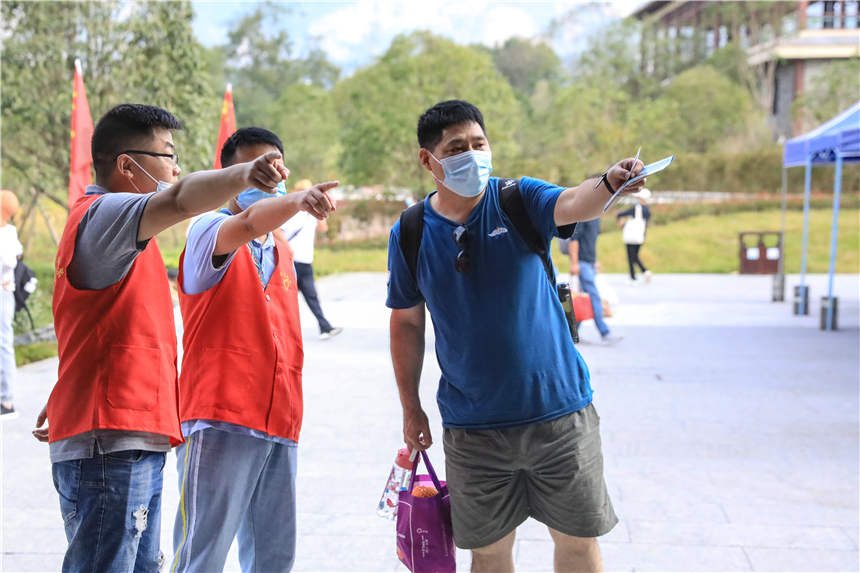 志愿者在景區(qū)內(nèi)為游客服務(wù)