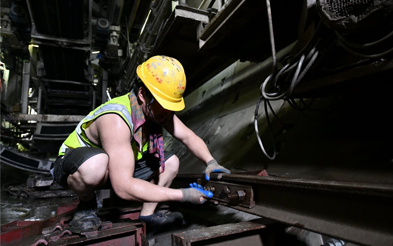 武漢地鐵19號線隧道中氣溫直逼40℃，中鐵十一局城軌公司一名工人正在進行鋪軌作業(yè)。張璽攝
