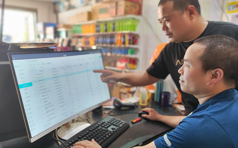 工作人員指導(dǎo)工業(yè)園大街客戶使用現(xiàn)代化的店鋪管理系統(tǒng)。