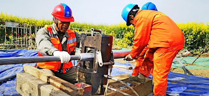 施工人員開展跨江導(dǎo)線接線管壓接作業(yè)。李健波攝