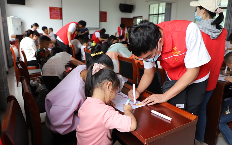 志愿者與孩子們同繪一幅畫，寫上真摯的祝福