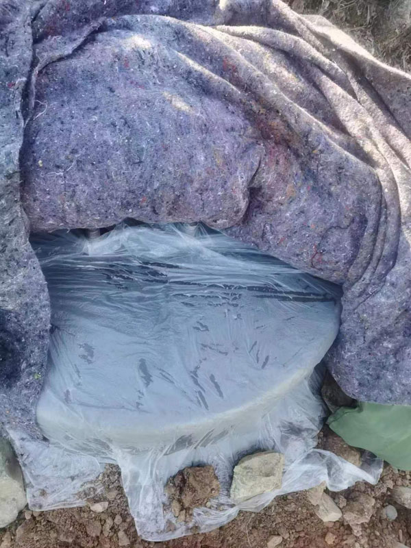 圖5：為保護(hù)電網(wǎng)鐵塔塔基，防止被凍壞，該公司項目工人將水泥澆筑后的塔基用保溫膜，棉氈，棉被層層包裹起來