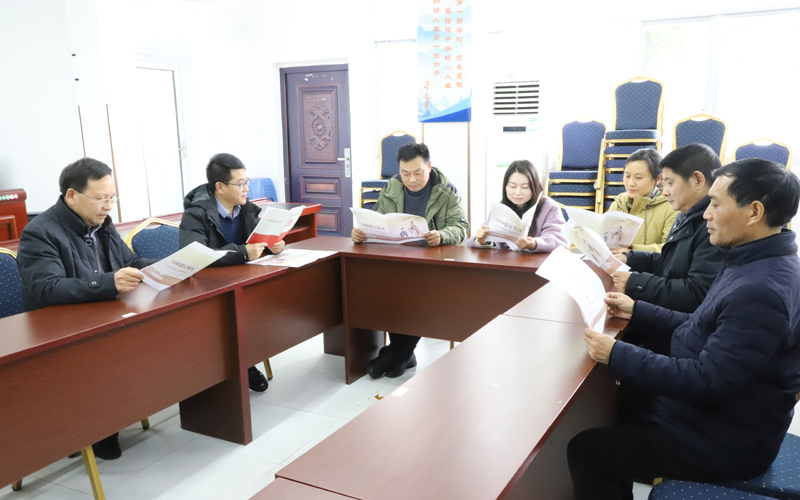 學(xué)校教師討論清廉學(xué)校建設(shè)宣傳冊。