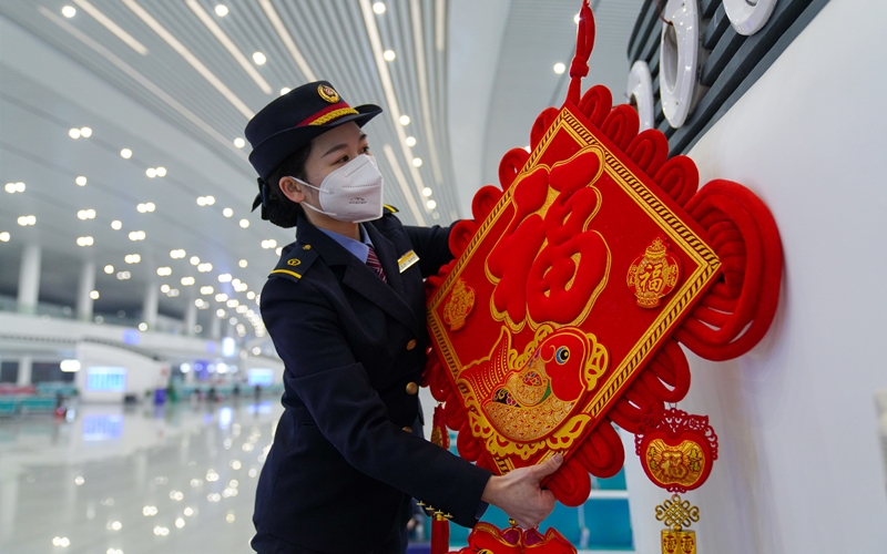 工作人員在站內(nèi)布置燈籠、中國(guó)結(jié)、窗花等新年飾品。李濤攝 