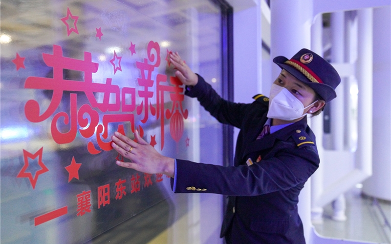 工作人員在站內(nèi)布置燈籠、中國(guó)結(jié)、窗花等新年飾品。李濤攝