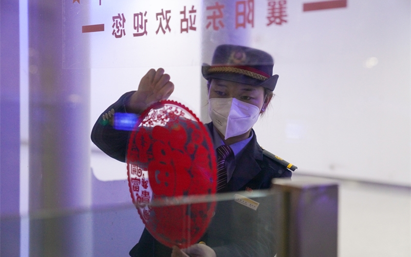 工作人員在站內(nèi)布置燈籠、中國結(jié)、窗花等新年飾品。李濤攝