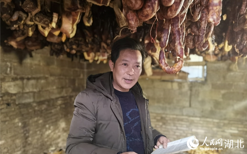 孫宜宗拿著小本本介紹臘肉預(yù)定情況。人民網(wǎng) 周雯攝