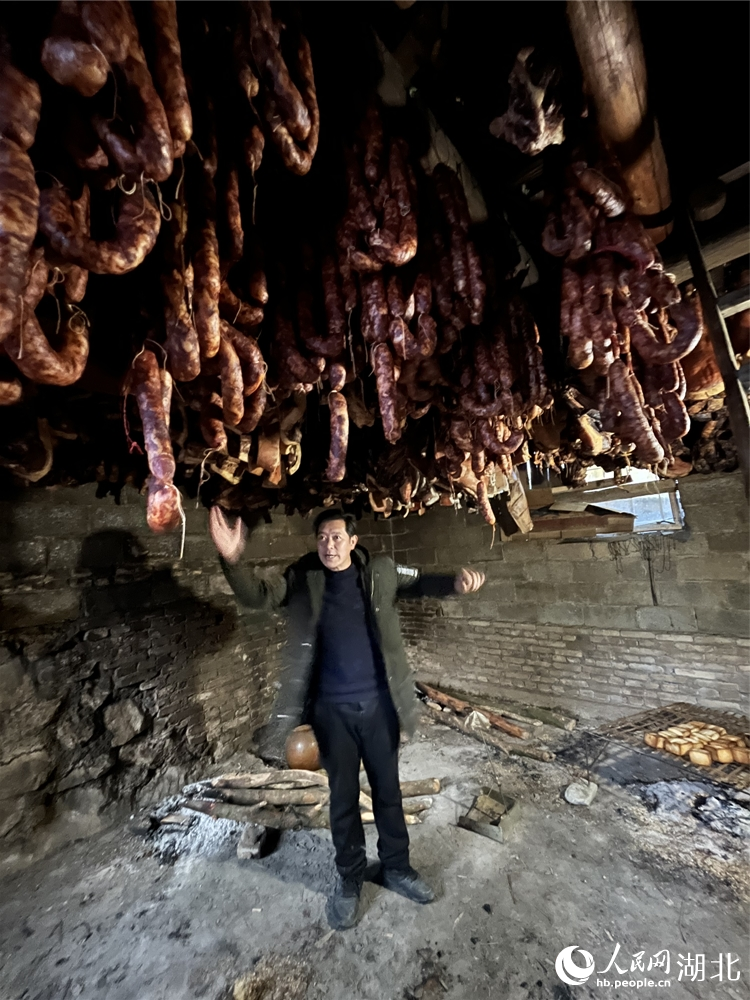 孫宜宗介紹臘肉熏制過程。人民網(wǎng) 張雋攝