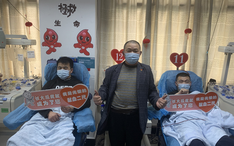李光明（中）和他的獻(xiàn)血“接班人”。武漢血液中心供圖