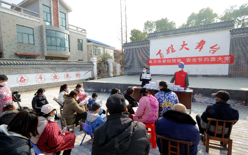 國網(wǎng)湖北電力員工在廣場上“搭臺唱戲”，為村民們耐心講解節(jié)約用電小常識。（余健兵 攝）