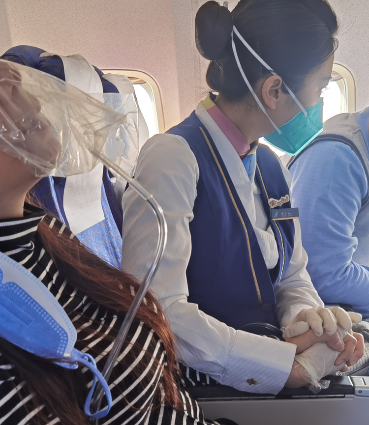 乘務(wù)長郭玉（右）握著旅客的手。南航湖北分公司供圖