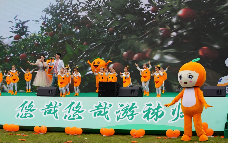 朋友身著臍橙服飾與秭歸臍橙IP形象“臍臍、橙橙”臺(tái)上臺(tái)下共舞。周華山攝