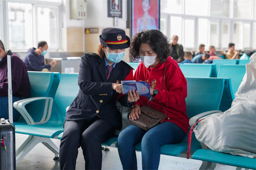 工作人員為過往旅客普及國家安全知識。李濤攝