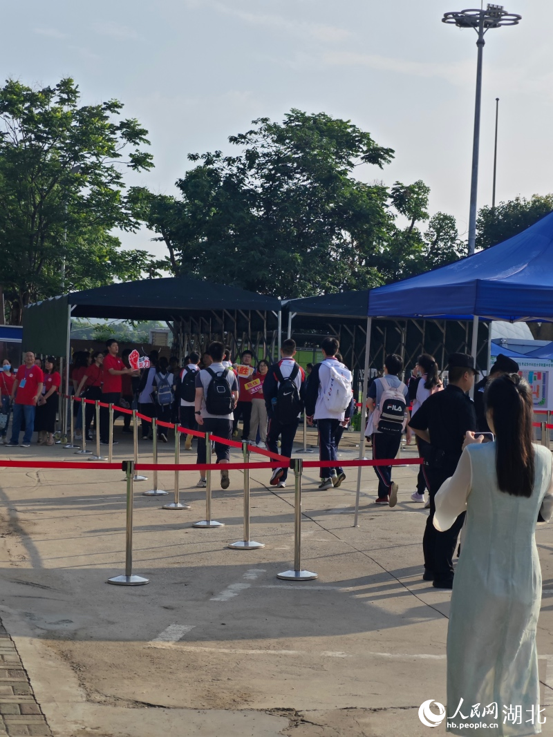 華中科技大學(xué)附屬中學(xué)考點外，老師紛紛舉著有祝福標語的牌子，為考生加油。人民網(wǎng)記者 周雯攝