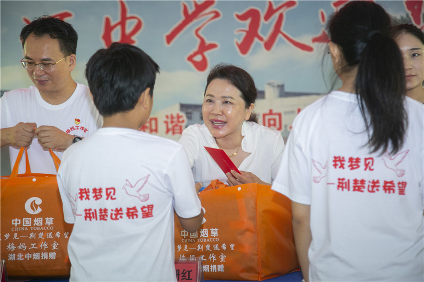 “梅媽工作室”揭牌活動上為受助學(xué)生們發(fā)放學(xué)習(xí)物資和生活用品。張慰攝