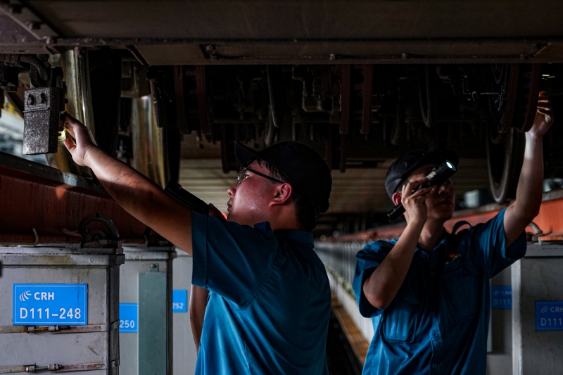 動車組機(jī)械師在對列車進(jìn)行檢修。鄒政攝