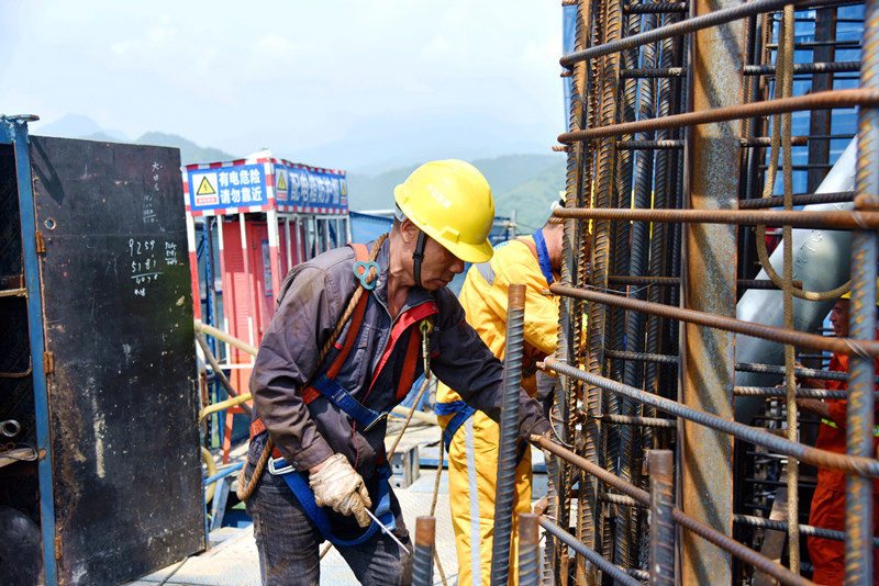 7月11日上午10點，十巫北高速控制性工程漢江特大橋南岸主塔130米高的施工現(xiàn)場，這里的氣溫直逼50度，大橋建設者正在進行鋼筋綁扎施工。伍進波攝