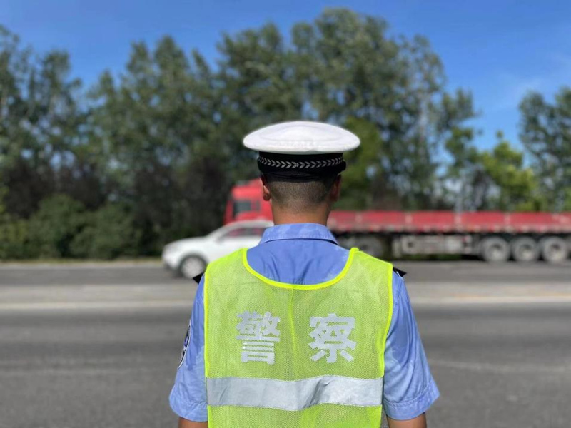 荊門交警在迎春大道執(zhí)勤照片，高溫天氣下，不一會(huì)兒汗水就打濕了后背。陳慧霖?cái)z