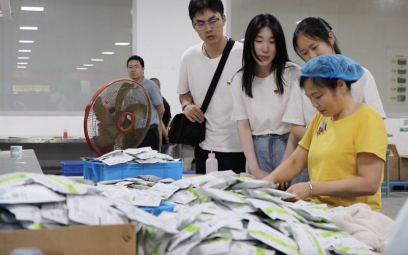 實踐隊員與工廠工人交談。