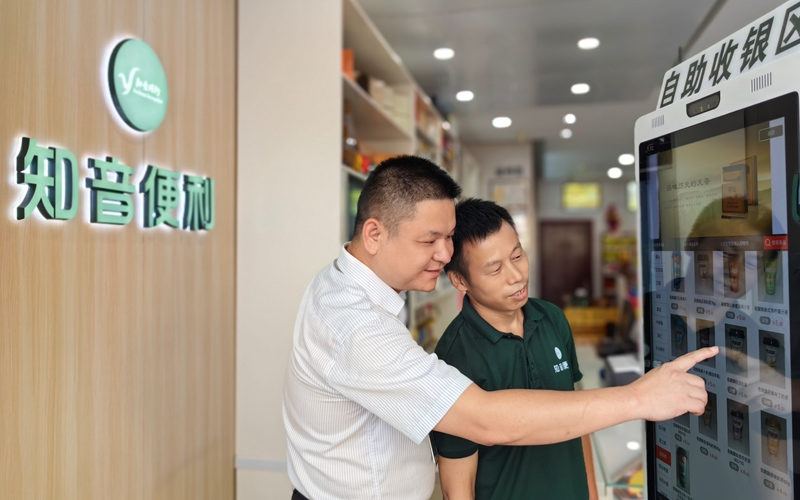 客戶(hù)經(jīng)理指導(dǎo)零售客戶(hù)使用智能工具管理店鋪。夏明洲攝