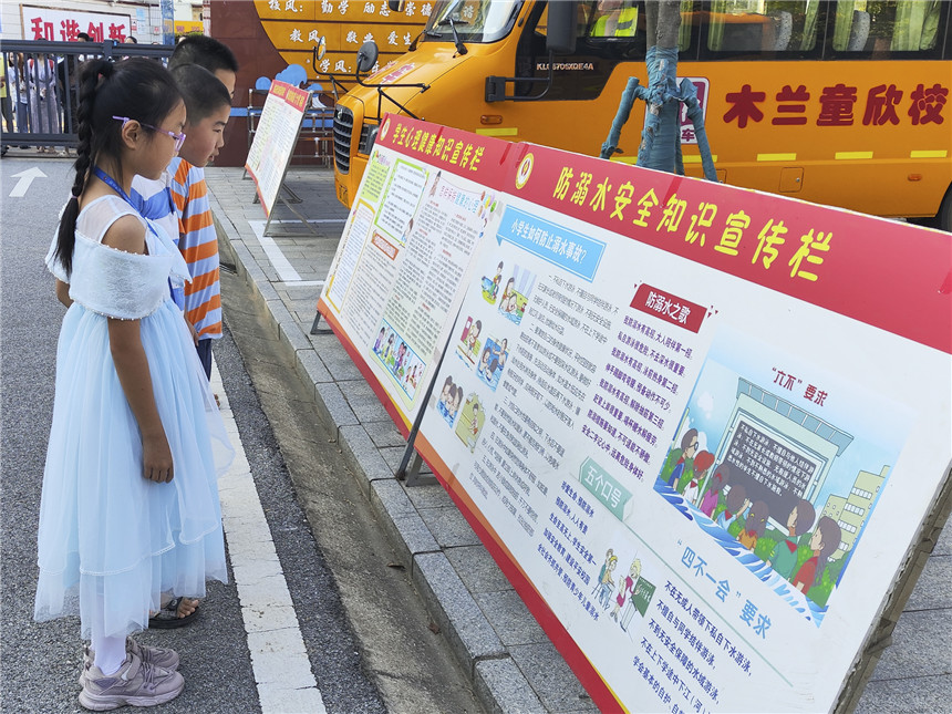 羅漢小學(xué)學(xué)生開(kāi)學(xué)第一天（觀看安全宣傳牌）。黃軒攝。