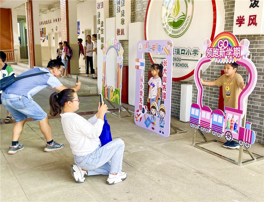 灄口小學勵志框前留個影。黃軒攝。