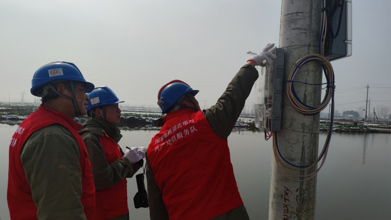 武漢供電公司漲渡湖供電所低壓外勤班班長姚勝華和同事正在檢查西灘湖村里的電表。人民網(wǎng)記者 周恬攝