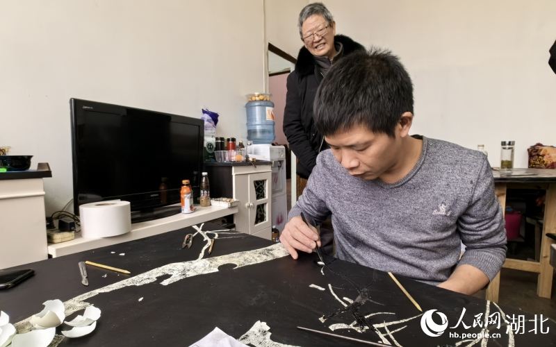 田亞正在趕制壩漆工藝品，師傅洪克儉在一旁指導(dǎo)。人民網(wǎng)記者 周雯攝