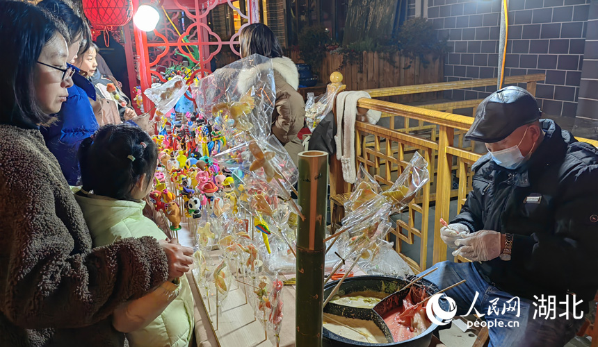 小朋友在看傳統(tǒng)藝人捏糖人。人民網(wǎng)記者 郭婷婷攝