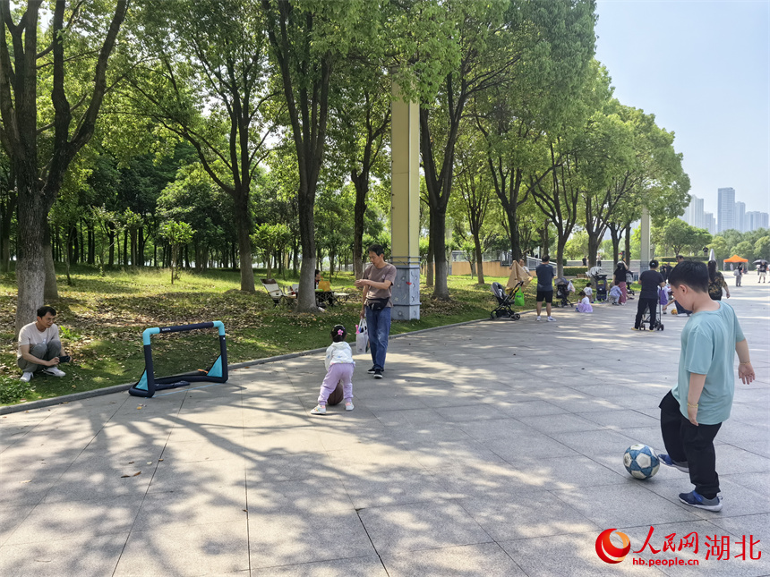 4月27日，在武漢漢江灣體育公園，兒童自備簡(jiǎn)易球筐，練習(xí)足球。人民網(wǎng)記者 周雯攝