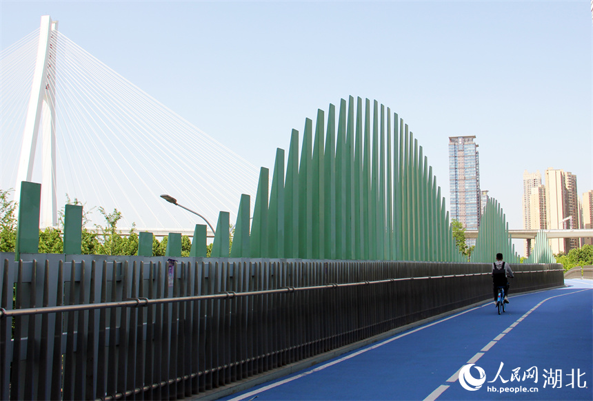 水波橋的造型創(chuàng)意來源于臨近的余家頭水廠。橋下車水馬龍，橋上是騎行慢生活。人民網(wǎng)記者 周恬攝