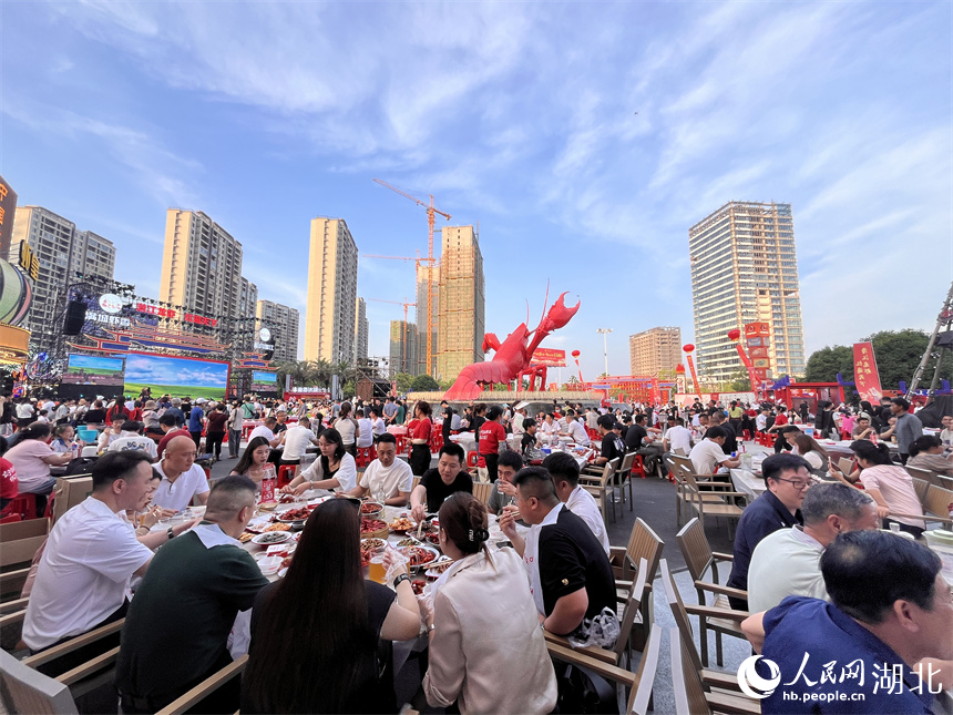 三五成群的食客手口并用，大快朵頤，品嘗著一盤盤色澤飽滿、醇香味美的小龍蝦。人民網(wǎng)記者 張雋攝 