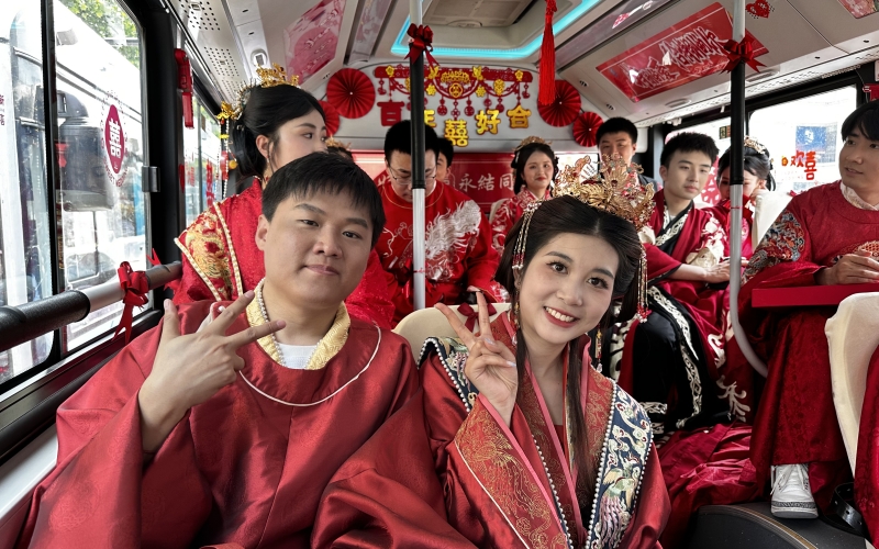 新人集體乘坐公交婚車，踐行低碳環(huán)保新風(fēng)尚。