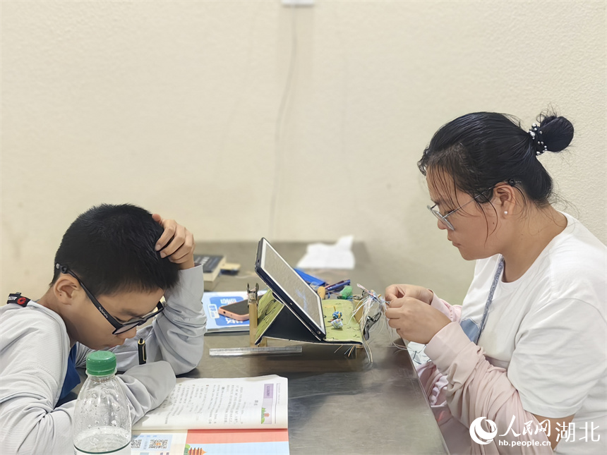 市民帶著小孩在納涼點讀書學習。人民網(wǎng)記者 肖璐欣攝