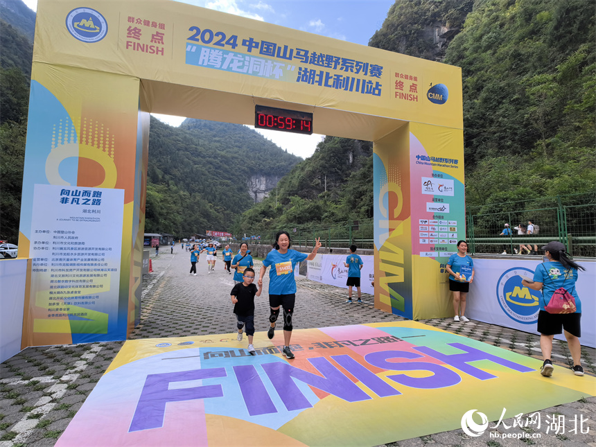 6.8公里群眾健身賽參賽選手帶著孩子通過終點。人民網(wǎng)記者 周雯攝