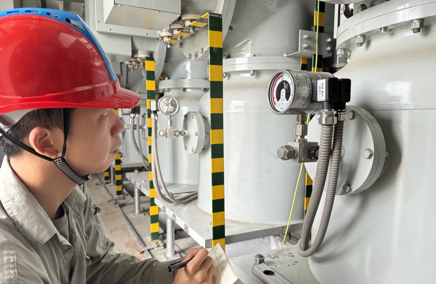 魯臺(tái)220千伏變電站，現(xiàn)場施工人員佘滕霄正在進(jìn)行密度繼電器壓力預(yù)檢查工作。陳浩攝