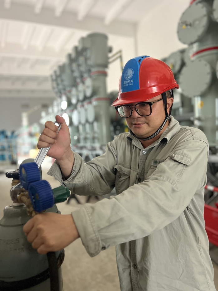 武漢鄧西220千伏變電站GIS區(qū)域，現(xiàn)場(chǎng)施工人員韓璐正在對(duì)已安裝完成的GIS設(shè)備進(jìn)行混氣氣體的充入工作。韓璐攝