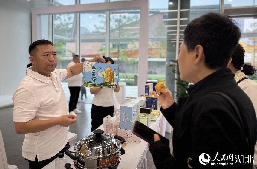市民在武漢人民網(wǎng)“夢(mèng)幻靈境”AI展演中心品嘗來(lái)自吉林的玉米。人民網(wǎng)記者 周恬攝