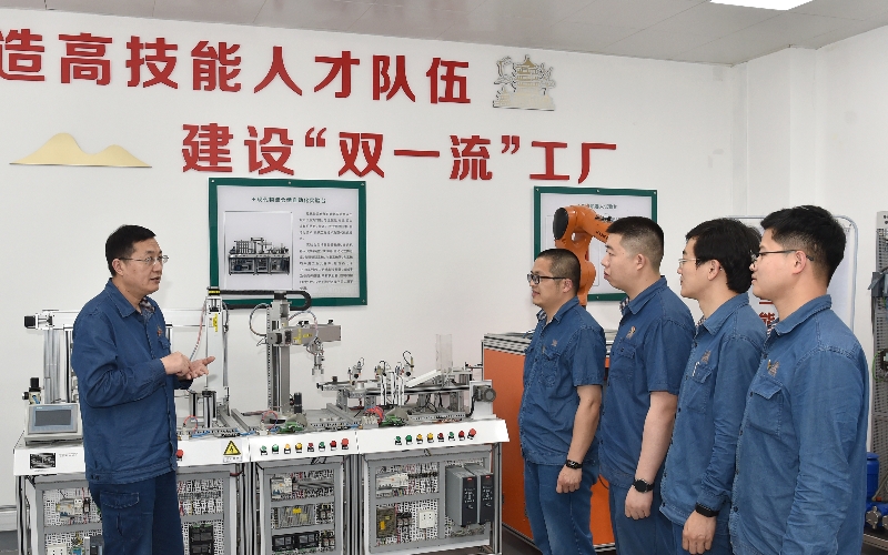 全國煙草行業(yè)技術(shù)能手、湖北省勞動模范王志強(qiáng)（左）與青年員工交流傳授電控知識。汪鑫攝