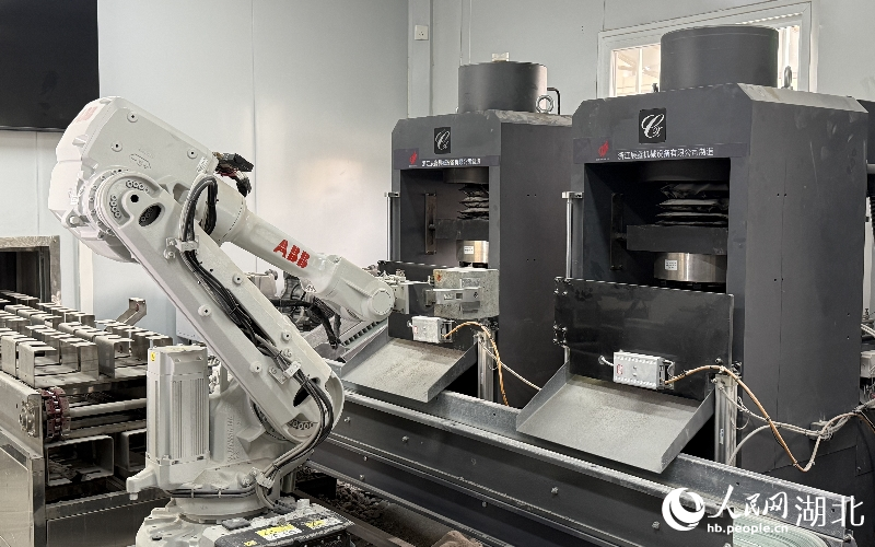 鄂州花湖機(jī)場高速公路二期工程試驗(yàn)室的機(jī)械臂將試件放入壓力機(jī)檢測。人民網(wǎng)記者 周恬攝