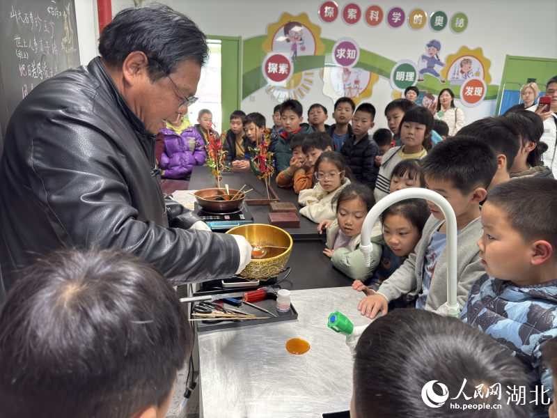 范耀堂教同學(xué)們“吹糖人”。人民網(wǎng)記者 張雋攝