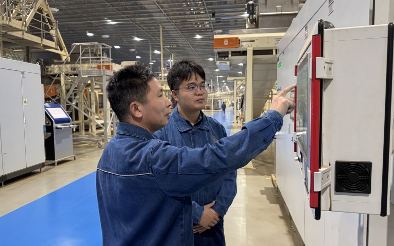 老員工為新員工講解烘絲機使用原理。 袁帥攝