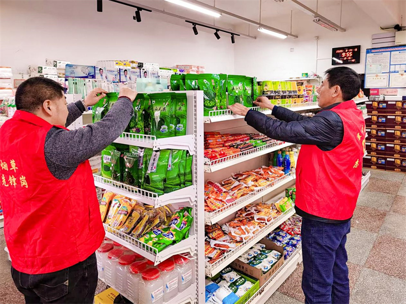 為煙草工作人員幫助零售戶整理貨架。史學(xué)文攝