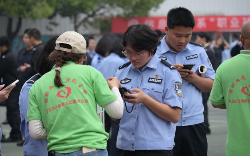 在志愿者的引導(dǎo)下，參與獻(xiàn)血的學(xué)生們正在手機(jī)上登記填表。武漢警官職業(yè)學(xué)院供圖