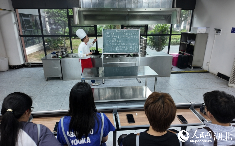 老師正在教授烹飪小龍蝦的技巧。人民網(wǎng)記者 周雯攝