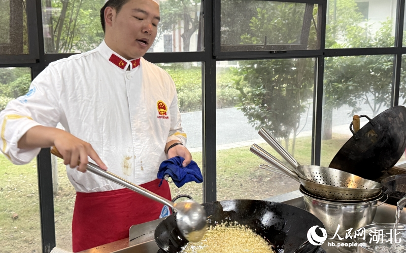 任課教師尉軒正在烹飪蒜蓉小龍蝦。人民網(wǎng)記者 張雋攝