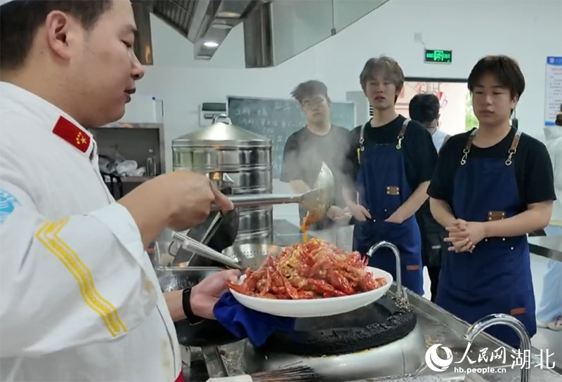 同學(xué)們目不轉(zhuǎn)睛地學(xué)習烹飪技術(shù)。人民網(wǎng)記者 周雯攝