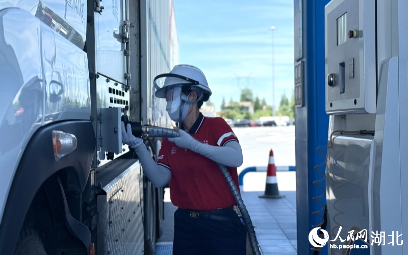 工作人員正在給氫能重卡加氫。人民網(wǎng)記者 周恬攝
