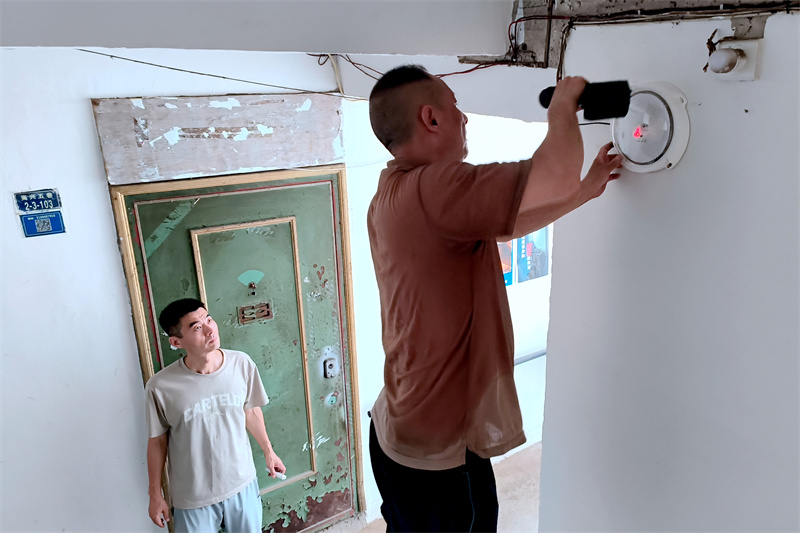 工作人員在樓梯口安裝太陽能路燈